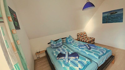 Schlafzimmer mit gemütlichem Doppelbett und Schlafsessel Schlafzimmer mit gemütlichem Doppelbett und Schlafsessel